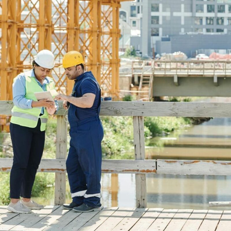 Construction professionals reviewing project data on-site using unified vendor management software.