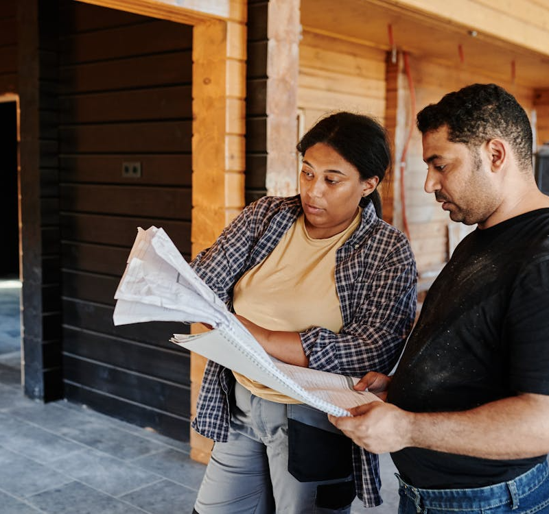 Construction team reviewing plans on-site using real-time construction CRM to prevent errors and improve coordination